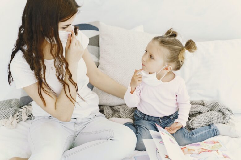 Mother and baby at home with medical masks